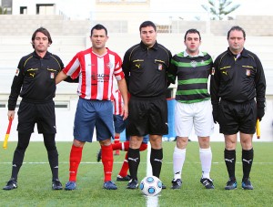 El trío arbitral con los capitanes del partido