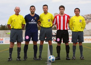 El trío arbitral con los capitanes del partido