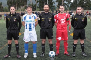 El trio arbitral con los capitanes del partido