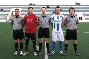 El trio arbitral con los capitanes del partido