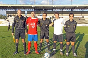 El trio arbitral con los capitanes del partido