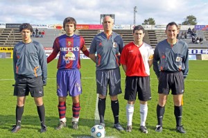 El trio arbitral con los capitanes del partido