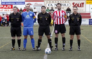 El trio arbitral con los capitanes del partido