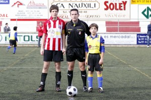 El colegiado con los capitanes del partido