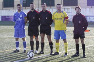 El trío arbitral con los capitanes del partido