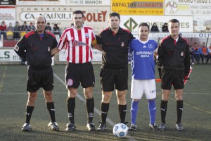 El trío arbitral con los capitanes del partido