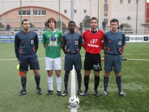 El trio arbitral con los capitanes del partido