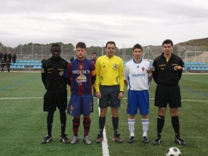 El trío arbitral con los capitanes del partido