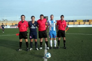 El trio arbitral con los capitanes del partido