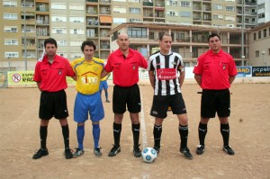 El trio arbitral con los capitanes del partido