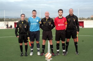 El trio arbitral con los capitanes del partido