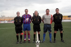 El trio arbitral con los capitanes del partido