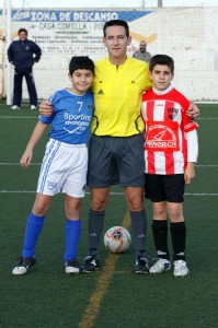 El colegiado con los capitanes del partido