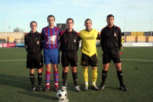 El trío arbitral con los capitanes del partido