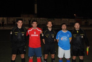 El trio arbitral con los capitanes del partido