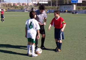 Colegiado con los capitanes del partido