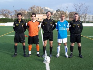 El trío arbitral con los capitanes del partido