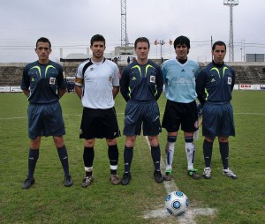 El trío arbitral con los capitanes del partido