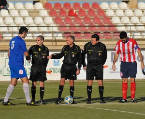 El trío arbitral con los capitanes del encuentro