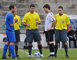 El trío arbitral con los capitanes del partido