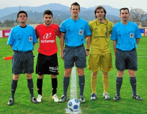 El trío arbitral con los capitanes del partido