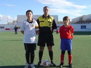 Colegiado con los dos capitanes del partido