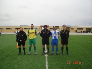 El trio arbitral con los capitanes del partido