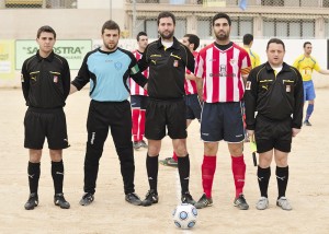 El trío arbitral con los capitanes del partido