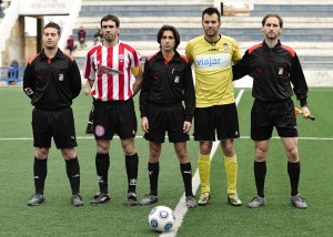 El trío arbitral con los capitanes del partido