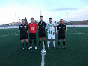 El trio arbitral con los capitanes del partido