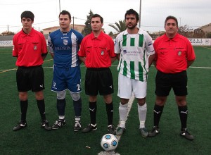 El trio arbitral con los capitanes del partido