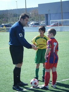 El colegiado con los capitanes del partido