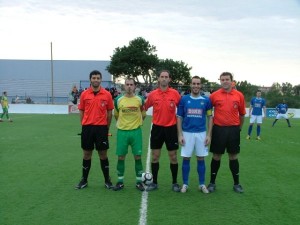 El trío arbitral con los capitanes del partido