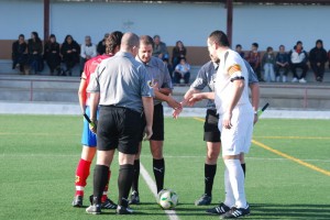 El trio arbitral con los capitanes del partido