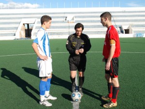 El colegiado del partido con ambos capitanes