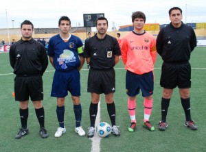 El trío arbitral con los capitanes del partido