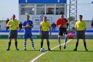 El trío arbitral con los capitanes de ambos equipos