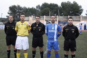 El trío arbitral con los capitanes del partido