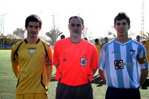 El colegiado con los capitanes del partido