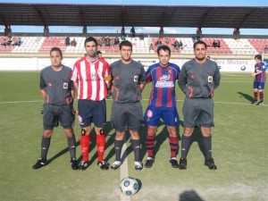 El trio arbitral con los capitanes del partido