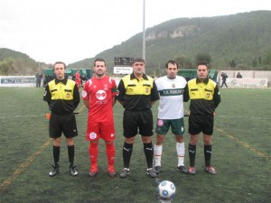 El trio arbitral con los capitanes del partido