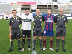 El trio arbitral con los capitanes del partido