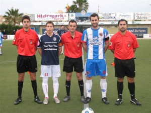 El trío arbitral con los capitanes del partido