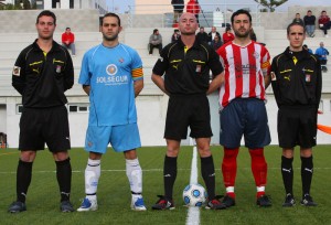 El trío arbitral con los capitanes del partido