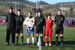 El trio arbitral con los capitanes del partido