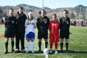 El trío arbitral con los capitanes del partido