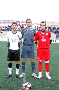 El colegiado con los capitanes del partido