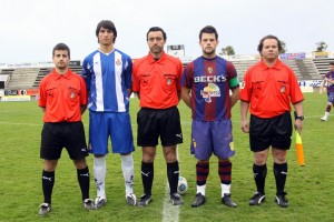 El trío arbitral con los capitanes del partido