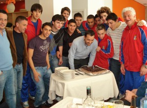 José Tirado sopla las velas de la tarta de cumpleaños junto a sus jugadores