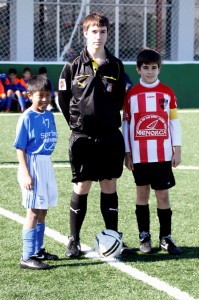 Arbityro del partido con los dos capitanes